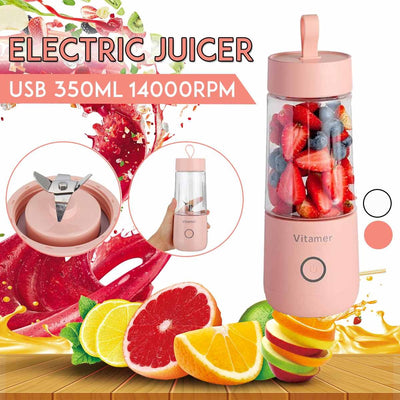 Pink electric juicer with fruits and juice splashes on a wooden surface
